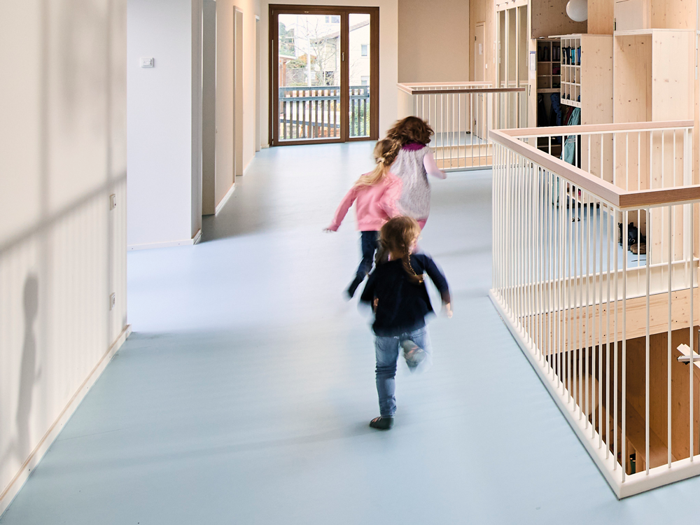 Kinder sausen durch einen Kindergarten-Flur